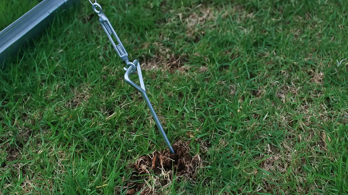 Kit d’ancrage de serre fixé dans un sol en herbe