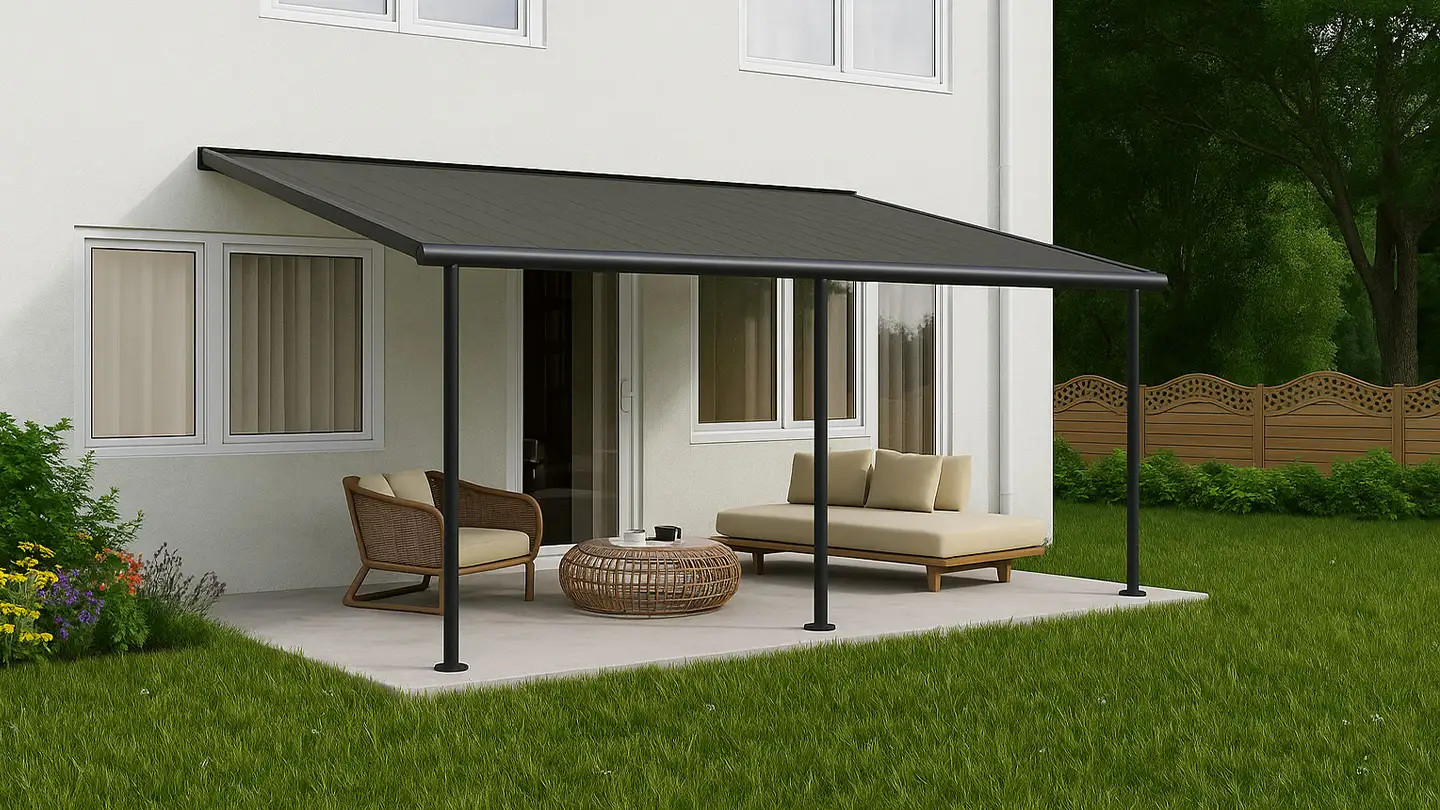 Modern patio cover attached to a white house, shading a cozy outdoor seating area with rattan furniture, set on a concrete patio surrounded by a green lawn and colorful garden plants.